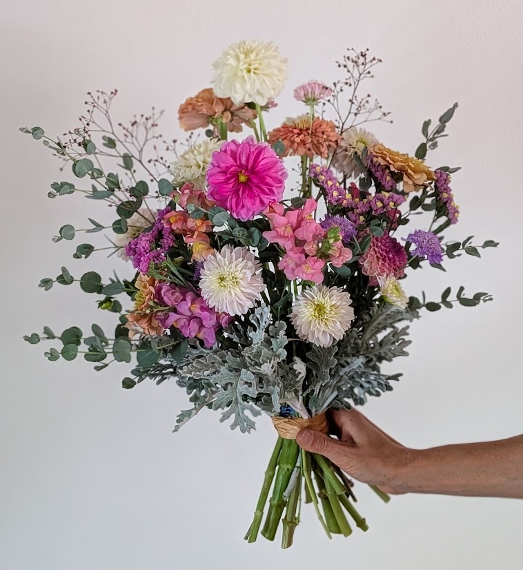 A hand-tied bouquet with dahlias, eucalyptus, and dusty miller